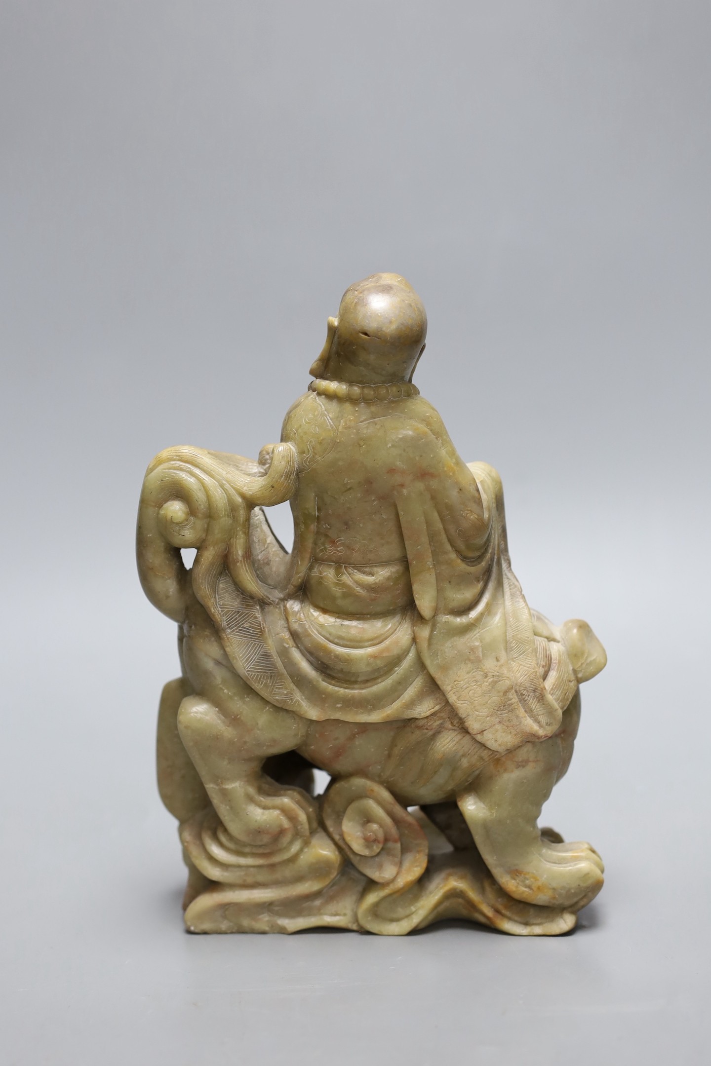 A Chinese soapstone group of a luohan riding a lion, 20cm